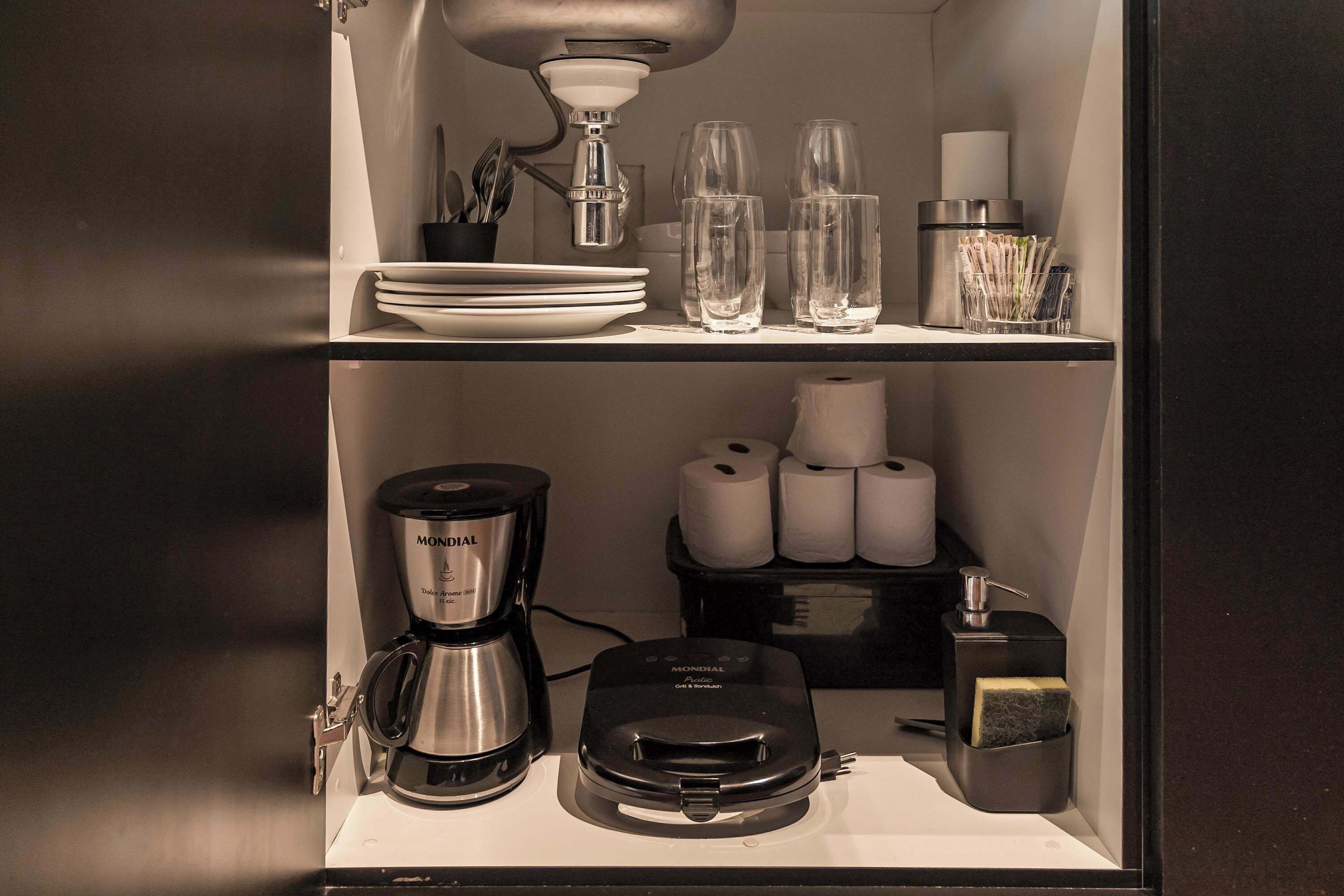 Een keuken met een koffiezetapparaat, een blender en een broodrooster op het aanrecht.