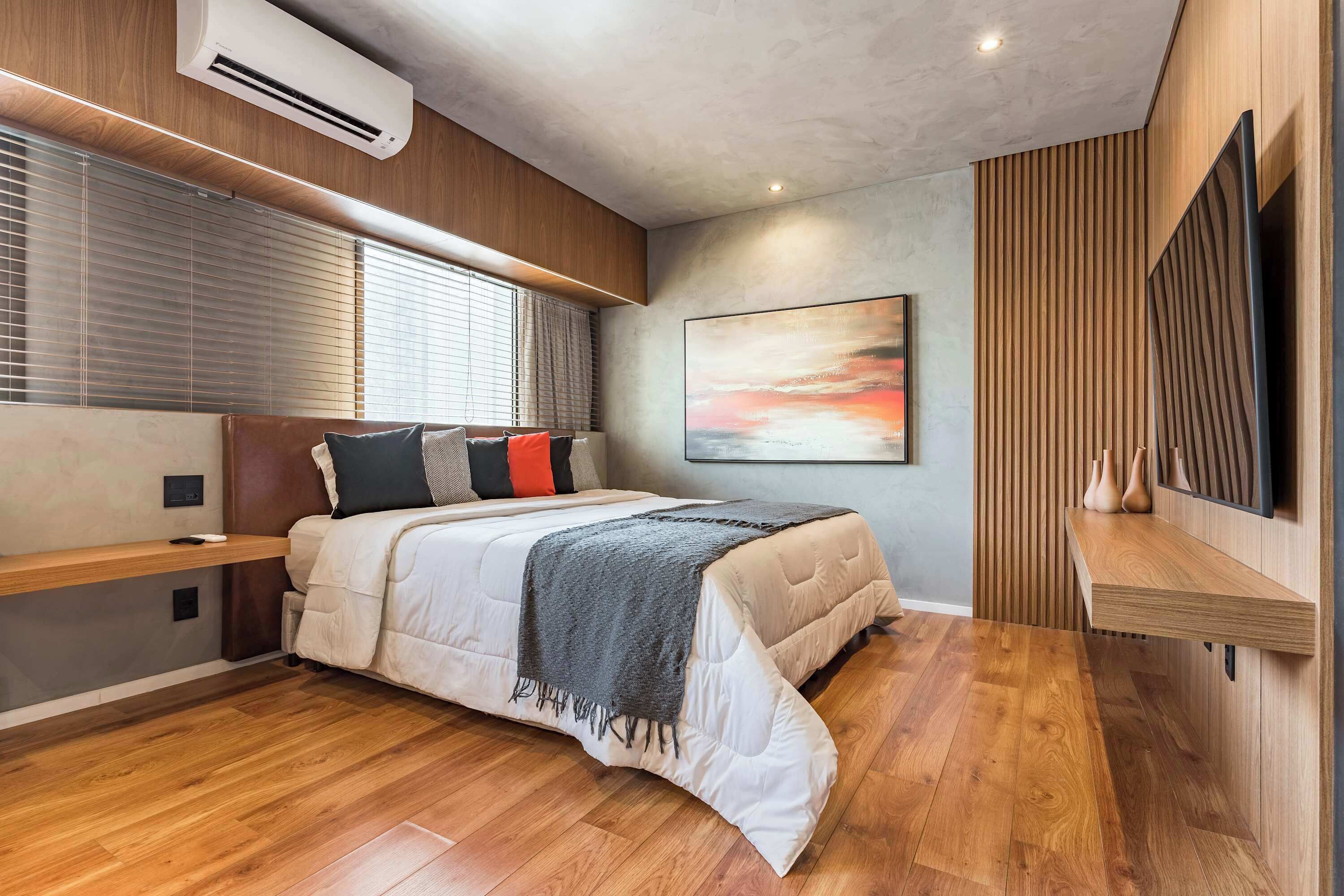 Quarto moderno com cama, estantes embutidas, televisão fixada na parede e uma grande pintura abstrata.