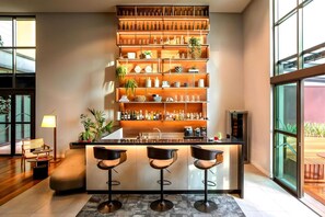Eine moderne Küche mit Bar, Holzböden mit Flaschen und einer Sitzecke mit Sofa und Sesseln.