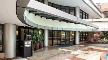 Un edificio moderno con una entrada curva, un mostrador de recepción y un vidrio que da al interior.