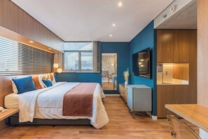 A modern bedroom with a bed, bedside tables, a desk, a TV, and a bathroom visible through a door. - Cyclinn a 400m do WTC Berrini Vila Olímpia #WB1812 (Berrini)