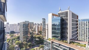 A high-rise building with a modern glass facade, surrounded by other high-rise buildings and greenery. - #VN1811 | Cyclinn Vila Olímpia (Vila Olímpia)