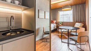A modern kitchen with a sink and countertop, a dining area with a table and chairs, and a bedroom with a bed and window.