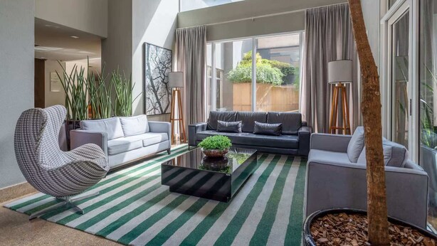 Un salon moderne avec un canapé, un fauteuil et une table basse.
