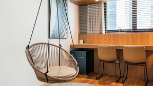 A modern kitchen with a hanging chair, a refrigerator, and a dining area with chairs. - Cyclinn a 400m do WTC Berrini Vila Olímpia #WB202 (Berrini)