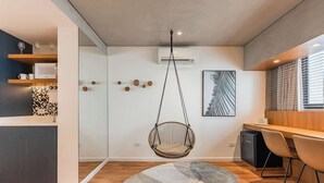 A modern kitchen with a hanging chair, a dining area with chairs, and a patterned rug. - Cyclinn a 400m do WTC Berrini Vila Olímpia #WB202 (Berrini)