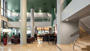 A spacious lobby with a curved staircase, multiple seating areas, and a bar. - Cyclinn a 400m do WTC Berrini Vila Olímpia #WB309 (Berrini)