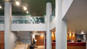 A modern hotel lobby with a reception desk, a staircase, and a second-floor balcony. - Cyclinn a 400m do WTC Berrini Vila Olímpia #WB309 (Berrini)