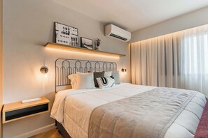 A modern bedroom with a bed, bedside tables, a wall-mounted air conditioner, and a window with curtains. - #EB806 | Cyclinn Brooklin Santo Amaro (Brooklin)