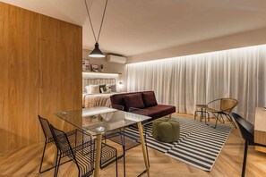 A modern living room with a glass dining table, black chairs, a red sofa, and a striped rug. - #EB806 | Cyclinn Brooklin Santo Amaro (Brooklin)