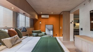 A modern bedroom with a bed, pillows, a green throw, and a desk area with a lamp. - Cyclinn a 400m do WTC Berrini Vila Olímpia #WB1403 (Berrini)