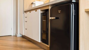 Eine moderne Küche mit einem schwarzen Kühlschrank, Holzschränken und einer Arbeitsplatte.