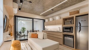 Uma cozinha moderna com eletrodomésticos embutidos, um sofá e uma área de jantar.
