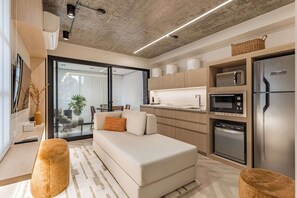 A modern kitchen with built-in appliances, a sofa, and a dining area. - #AT32 | Cyclinn Itaim Jesuino (Itaim Bibi)