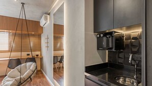 Moderni keittiö, jossa on sisäänrakennettu uuni, pesuallas ja riipputuoli.