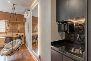 Eine moderne Küche mit Einbauofen, Spüle und einem Hängekorbstuhl.