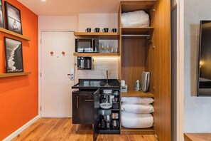 A compact kitchen with a microwave, coffee maker, and storage cabinets. - #WP402 | Cyclinn Paulista Jardins (Jardim Paulista)