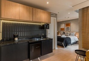 Eine moderne Küche mit Kaffeemaschine, Spüle und einem kompakten Kühlschrank.