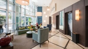 Un vestíbulo moderno con amplias ventanas, una zona de estar y una recepción.
