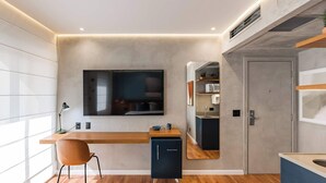 A modern kitchen with a built-in refrigerator, a wooden countertop, and a wall-mounted TV. - #IN607 | Cyclinn Jesuíno Arruda Itaim (Itaim Bibi)