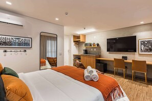 Ein modernes Hotelzimmer mit Bett, Schreibtisch, Fernseher und Bad.
