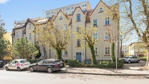 A multi-story residential building with a traditional architectural style, featuring a mix of window types and a central entrance. - Nadmorski Zakątek by Grand Apartments (Sopot)