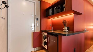 Une cuisine compacte équipée d’un réfrigérateur intégré, d’un four à micro-ondes et d’un évier.