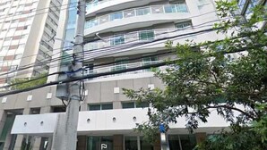 Un immeuble à plusieurs étages doté d’une architecture moderne, avec des balcons et de grandes fenêtres.