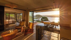 Una habitación moderna con cama, zona de estar y vistas al exterior.