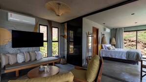 Una habitación moderna con sofá, mesa, cama y televisor.