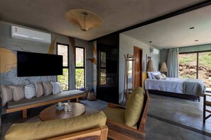 A modern room with a sofa, a table, a bed, and a TV.