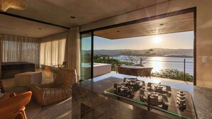 Ein modernes Wohnzimmer mit einem Glastisch, einer Ledersofa und Blick auf den Ozean.
