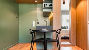Un petit coin repas avec une table et deux chaises, une porte verte et un plancher en bois.
