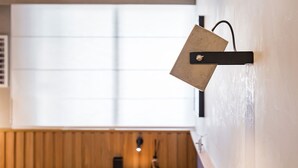 Eine moderne Küche mit Holzarbeitsplatte, einer hängenden Leuchte und einem Fenster mit Jalousien.