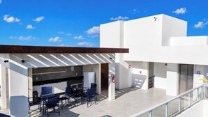 A rooftop terrace with outdoor seating, a fire extinguisher, and a view of the sky. - Flat Miray Exclusive com Piscina (Tamandaré)