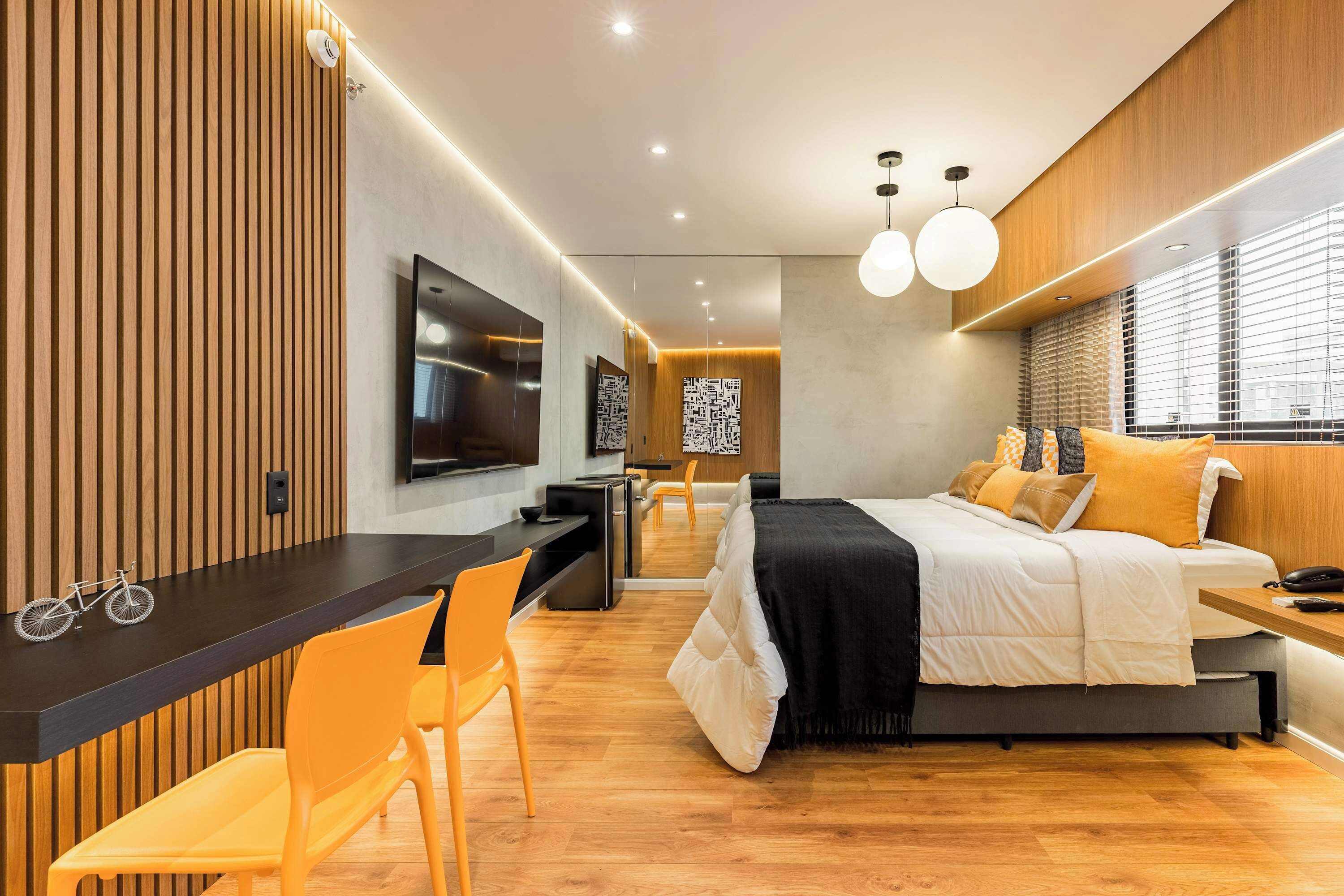 Une chambre d’hôtel moderne équipée d’un lit, d’un bureau et d’un coin salon.
