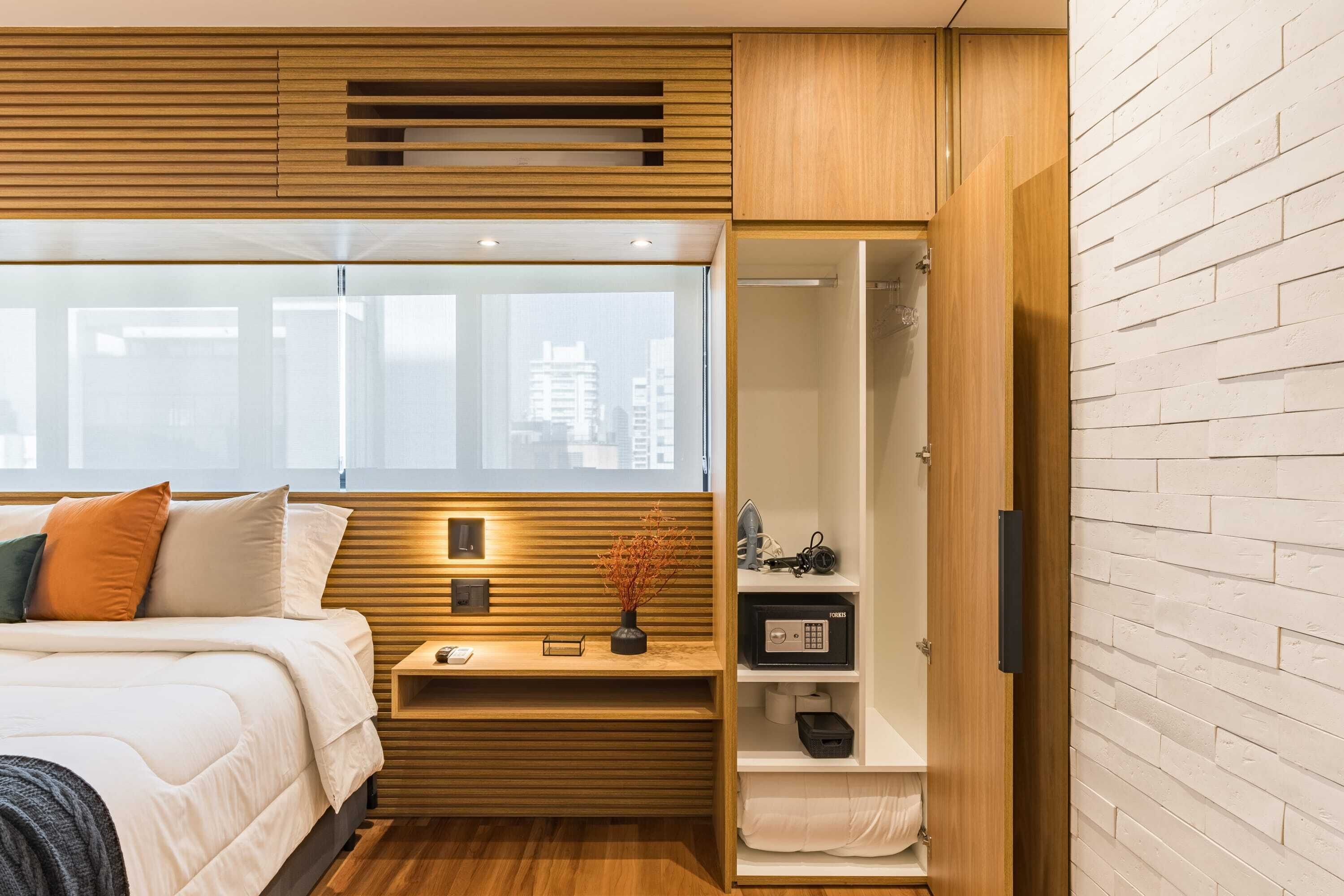 A modern bedroom with a bed, bedside table, and a wardrobe with a mirror.
