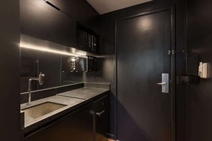 A modern kitchen with a built-in microwave, stainless steel appliances, and a dark-colored door. - Cyclinn a 400m do WTC Berrini Vila Olímpia #WB1703 (Berrini)