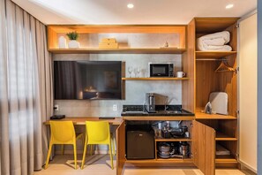 A compact kitchenette with a microwave, coffee maker, and storage cabinets. - #NP904 | Cyclinn Pinheiros (Pinheiros)