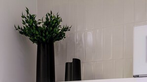 A modern kitchen with a stainless steel sink, a black faucet, and a potted plant on a white shelf. - Cyclinn a 400m do WTC Berrini Vila Olímpia #WB1301 (Berrini)