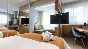 A hotel room with a bed, a desk, a television, a sofa, and a dining area. - #CA405 | Cyclinn Casa do Ator Vila Olímpia (Vila Olímpia)