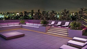A rooftop lounge with a sofa, lounge chairs, and a small table. - #CA405 | Cyclinn Casa do Ator Vila Olímpia (Vila Olímpia)