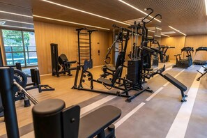 A gym with various exercise equipment, a bench, and a wall-mounted rack. - Studio Completo a 100m do Metrô Brooklin | HM1113 (Brooklin)