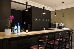 A bar area with a long counter, bar stools, pendant lighting, and a potted plant. - #TW2403 | Cyclinn Vila Olímpia (Itaim Bibi)