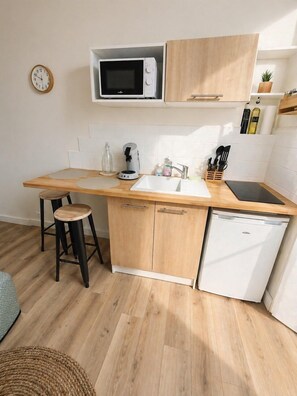 A compact kitchen with a microwave, coffee maker, sink, and dishwasher. - Le Petit Jean Alexandre – Studio centre-ville (Poitiers)