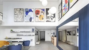 A modern hotel lobby with a reception desk, seating area with chairs, and artwork on the walls. - Flat a 300m do Metrô Consolação | BC1108 (Bela Cintra)