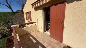 A house with a covered patio, a door, and a window. - The House of Seasons (Apt)