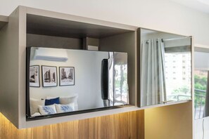 A modern kitchen with a built-in refrigerator, a wooden countertop, and a large window with a view of a building outside. - Studio Completo a 5 min do Nubank Parque | GP85 (Perdizes)