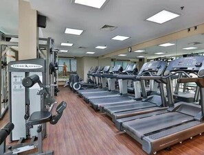 A gym with multiple treadmills, a weight machine, and a mirror on the wall. - #RD303 | Cyclinn Vila Olímpia (Vila Olímpia)