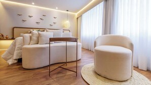 Een moderne slaapkamer met een bed, een ronde fauteuil, een klein tafeltje en een wand met decoraties in de vorm van vogels.